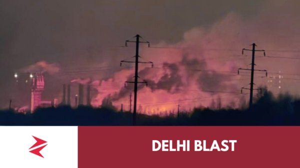 Emergency responders at a burning industrial facility at night