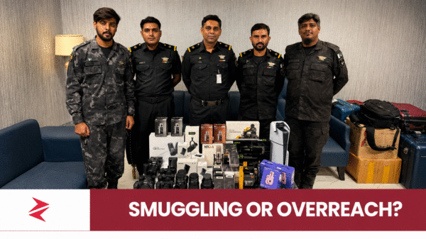 Pakistan Customs officers displaying undeclared cameras, lenses and a PS5 recovered at Karachi Airport