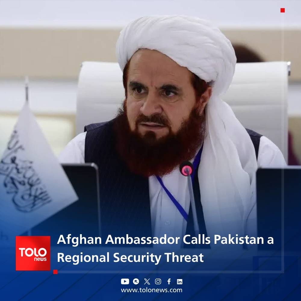Afghan Taliban ambassador to Russia Gul Hassan Hassan speaking at a Moscow security conference, wearing a white turban and dark vest, microphone in hand